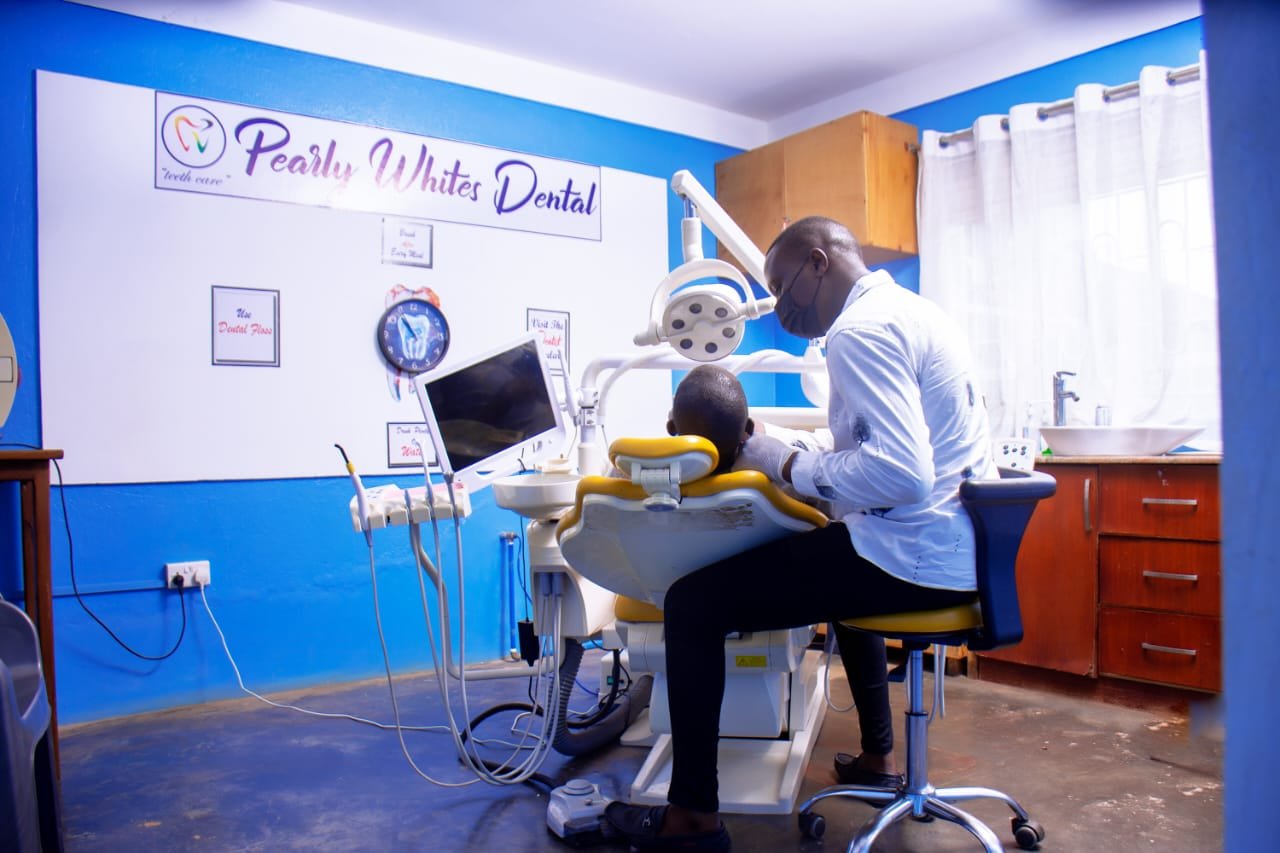 Dentist examining patient in dental clinic with blue walls and modern equipment